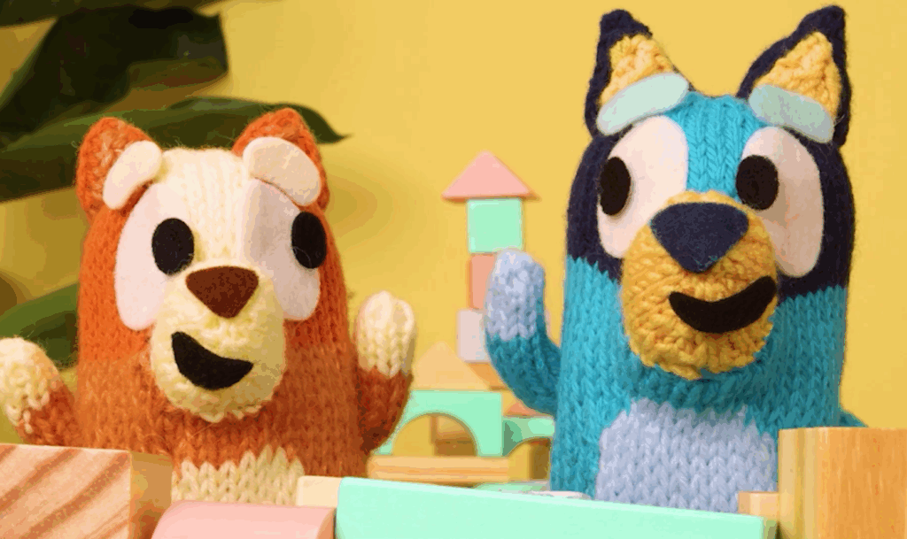 Bluey and Bingo felt puppets playing with wooden blocks on a stop-motion set for kids’ entertainment content.