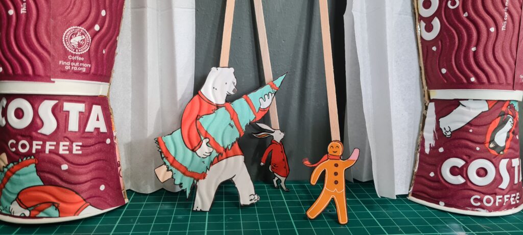 Costa Coffee cups framing papercraft characters on a stop-motion food & drink commercial set.