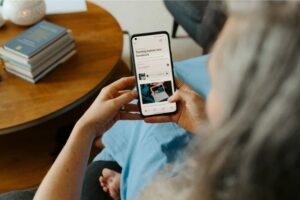 A person holding a smartphone and scrolling through a "Turning failure into feedback" social media post by Studio Gently, a creative production agency in the UK.